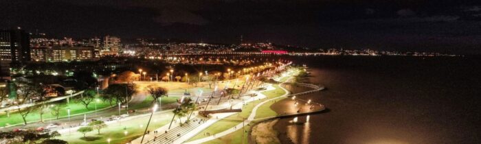 Nachtopname van de verlichte Costanera en skyline van Encarnación, Paraguay, langs de Paraná-rivier.